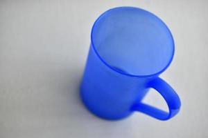 Mug en plastique bleu sur fond blanc photo