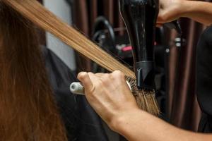 le coiffeur sèche les cheveux du client avec un sèche-cheveux photo