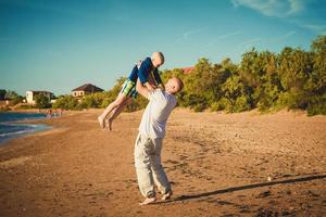 heureux père et fils marchant sur la plage photo