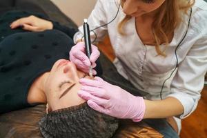 dans le salon de beauté chez le tatoueur belle cliente heureuse photo