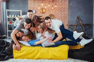 portrait de groupe de garçons et de filles multiethniques avec des vêtements colorés à la mode tenant un ami posant sur un mur de briques, des gens de style urbain s'amusant, des concepts sur le mode de vie de la jeunesse photo