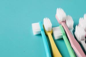 brosses à dents colorées sur fond vert clair photo