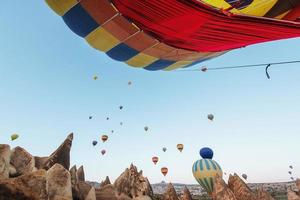 ballon à air chaud survolant le paysage rocheux en turquie. cappadoce photo