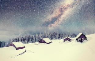 chalets à la montagne la nuit sous les étoiles. événement magique en journée glaciale. en prévision des vacances photo