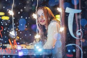 belle jeune femme assise dans un café, buvant du vin. noël, nouvel an, saint valentin, concept de vacances d'hiver photo