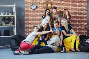 portrait de groupe de garçons et de filles multiethniques avec des vêtements colorés à la mode tenant un ami posant sur un mur de briques, des gens de style urbain s'amusant, des concepts sur le mode de vie de la jeunesse photo