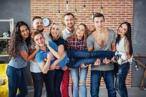 portrait de groupe de garçons et de filles multiethniques avec des vêtements colorés à la mode tenant un ami posant sur un mur de briques, des gens de style urbain s'amusant, des concepts sur le mode de vie de la jeunesse photo