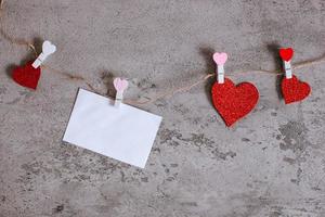 enveloppe blanche et papier en forme de coeur pincé sur une corde à linge photo
