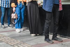 concept de distanciation sociale avec des personnes en file d'attente. visages méconnaissables, gros plan sur les pieds des jeunes respectant la disposition de la loi pour la pandémie de coronavirus photo