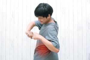 un jeune homme asiatique a ressenti de la douleur à la taille, concept de maux de dos, nerf pincé et syndrome myofascial, acide lactique dans les muscles et problèmes de colonne vertébrale, inflammation, lumbago photo