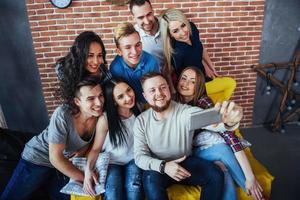 groupe de beaux jeunes gens faisant du selfie dans un café, meilleurs amis filles et garçons s'amusant ensemble, posant un concept de mode de vie émotionnel photo