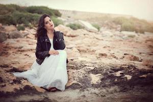 femme pensive assise sur les rochers photo