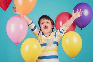 garçon heureux et souriant avec des ballons colorés photo