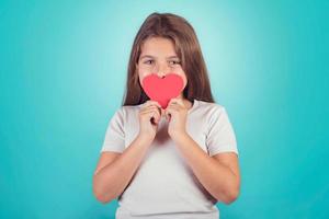 jeune fille souriante avec un coeur couvrant ses lèvres photo