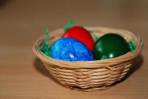 trois oeufs de pâques dans un panier de paille photo