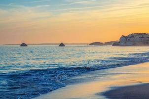 paysage de la belle plage de sable praia da rocha avec des rochers et des falaises dans la ville de portimao du district de l'algarve photo