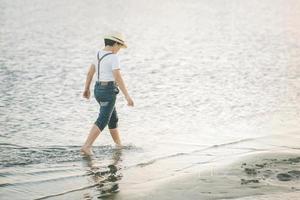 enfant marchant le long de la plage photo