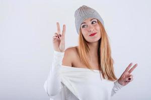 jeune femme souriante et drôle avec un chapeau d'hiver sur fond blanc photo