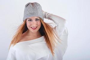 jeune femme souriante et drôle avec un chapeau d'hiver sur fond blanc photo