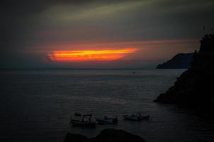 vue aérienne panoramique sur l'horizon, ciel dramatique au crépuscule du coucher du soleil, bateaux au premier plan, golfe de Gênes photo