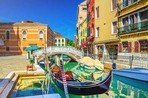 paysage urbain de venise avec gondole et bateaux à moteur amarrés sur un canal d'eau étroit photo