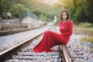 femme heureuse assise sur la voie ferrée photo