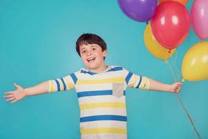 garçon heureux et souriant avec des ballons colorés photo