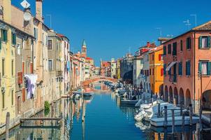 paysage urbain de chioggia avec veine étroite du canal d'eau avec bateaux multicolores amarrés photo