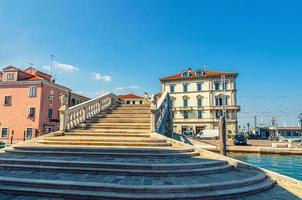 pont de pierre ponte di vigo avec des escaliers sur le canal d'eau de vena et de vieux bâtiments dans le centre historique de chioggia photo