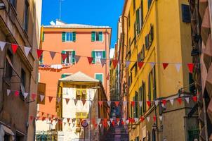 de petits drapeaux rouges et blancs pendent au-dessus de la rue avec des bâtiments multicolores colorés photo