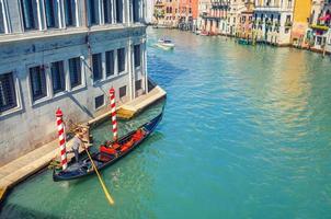Gondolier sur gondole à voile bateau traditionnel dans l'eau de la voie navigable du grand canal à Venise