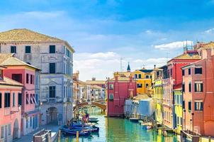 paysage urbain de chioggia avec veine étroite du canal d'eau avec bateaux multicolores amarrés photo