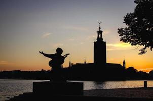silhouette de la statue d'evert taube et de l'hôtel de ville de stockholm, suède photo