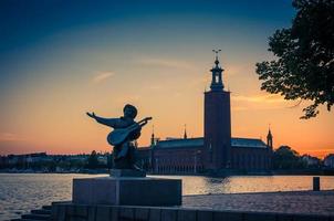 silhouette de la statue d'evert taube et de l'hôtel de ville de stockholm, suède photo