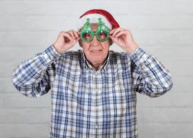 grand-père portant un chapeau de père noël et des lunettes amusantes photo