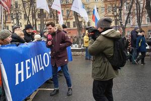 Moscou, Russie - 24 février 2019. Marche commémorative de nemtsov. Journaliste de la chaîne de télévision russe Aleksei Korostelev interviewant des manifestants portant une bannière politique photo