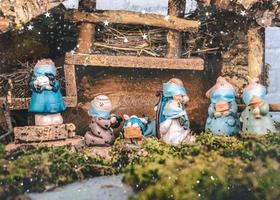 crèche de noël. figurines de statues de la nativité avec masques chirurgicaux protecteurs.scène de l'enfant né bébé jésus photo