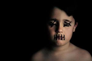 enfant avec visage peint sur fond noir photo