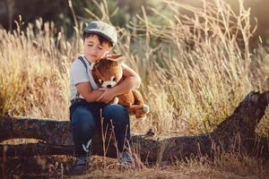 garçon étreignant son ours en peluche photo