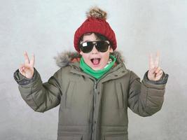 enfant heureux avec des lunettes de soleil et un chapeau d'hiver photo