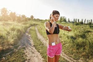 jeune fille fait du sport avec le gadget à portée de main photo