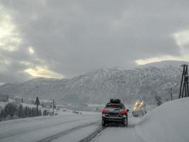 conduire à travers une route enneigée et un paysage en norvège. photo