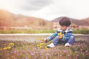 enfant heureux avec des fleurs au printemps photo