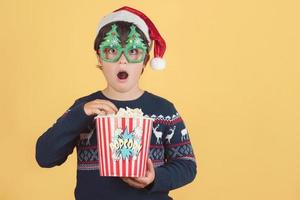 enfant surpris portant un chapeau de noël avec du pop-corn photo