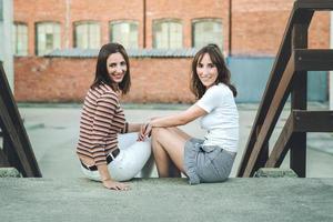 amis de jeunes femmes assis dans la rue photo