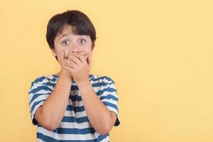 enfant couvrant sa bouche par les mains photo