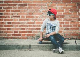 enfant avec skateboard et lunettes de soleil photo