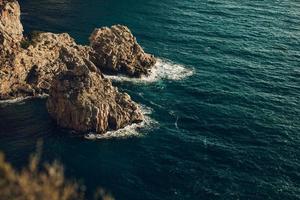 quelques rochers et une mer d'un bleu profond photo