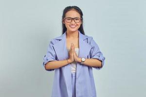 portrait d'une jolie jeune femme asiatique salue les mains avec un grand sourire isolé sur fond blanc photo