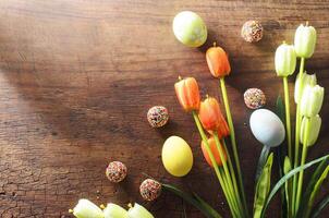 oeufs de pâques fantaisie et décoration de fleurs de tulipes sur fond de bois avec espace de copie pour votre texte photo